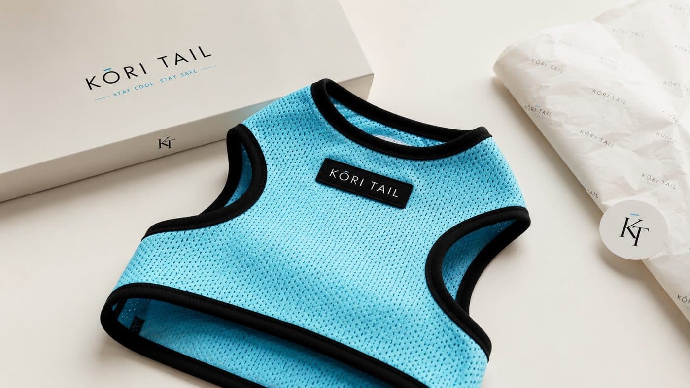A light-blue KŌRI TAIL vest laid flat on its branded box and tissue paper